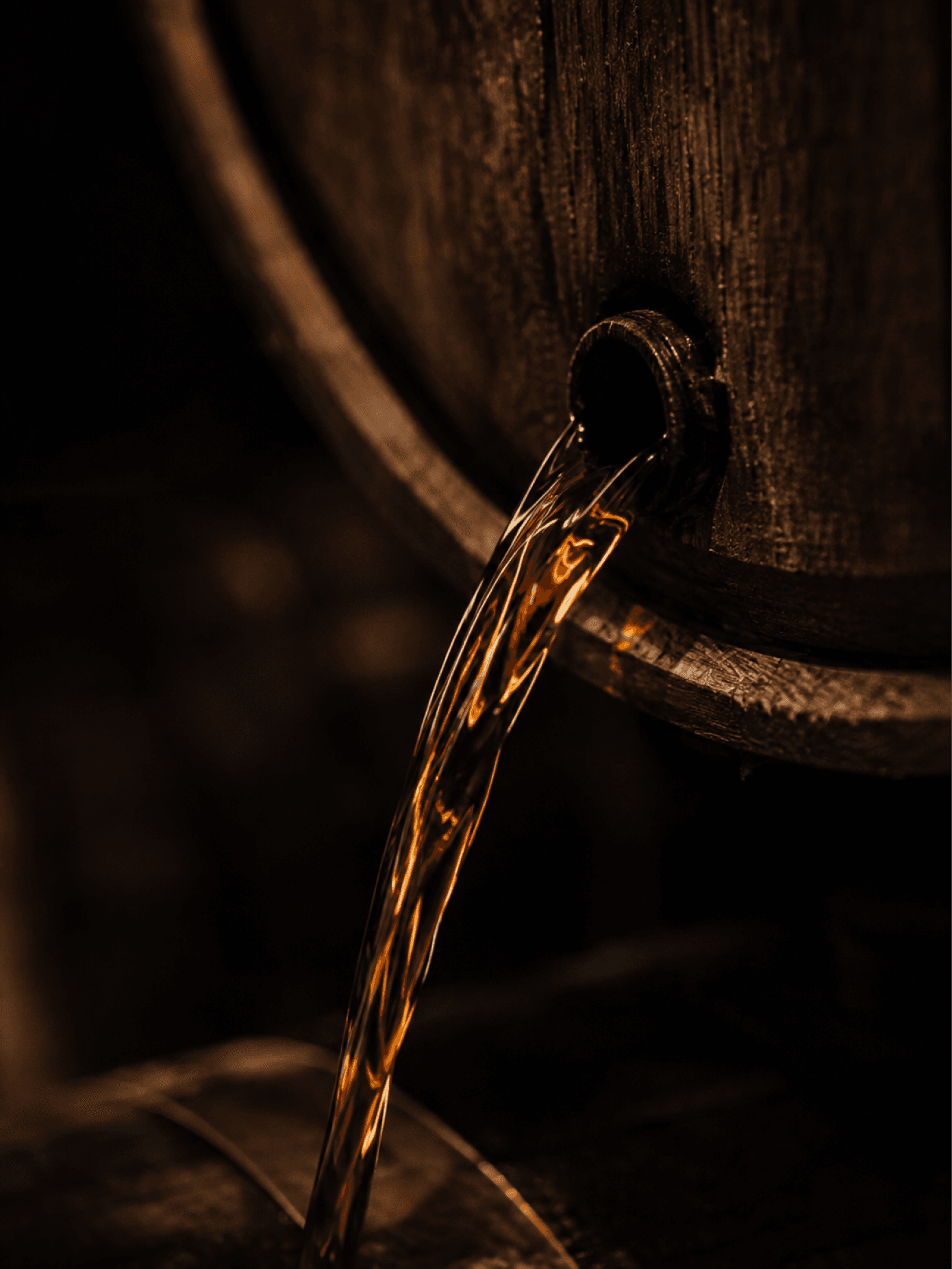 Bourbon running from a cask valve into a waiting glass
