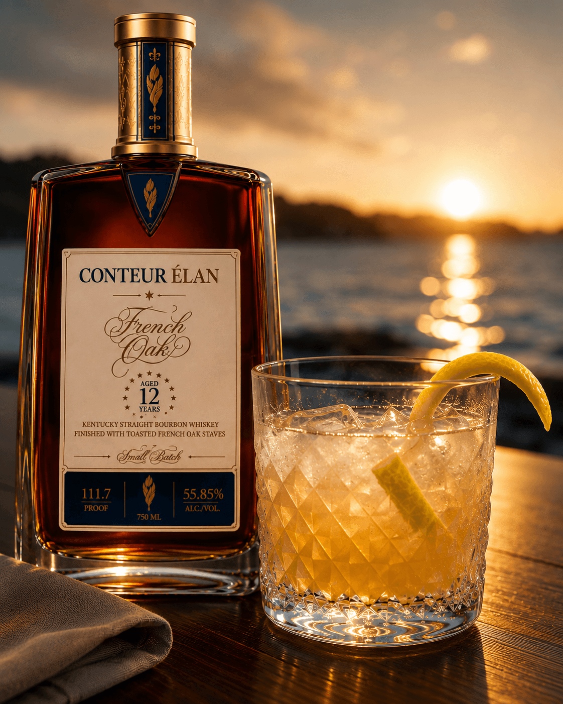 A Harbour Light serve on a wooden bar top at sunset, lemon twist garnish, water in the background.